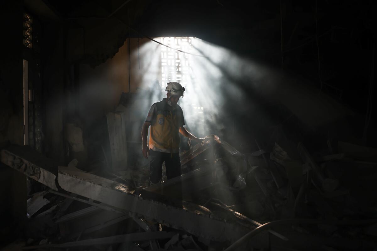 A member of Syria's civil defense works in the aftermath of an Israeli airstrike on Syria's defence ministry headquarters on July 16, 2025 in Damascus.The strikes come amid an escalation in conflict between Syrian government forces and Druze militia in the southern Syrian city of Sweida.