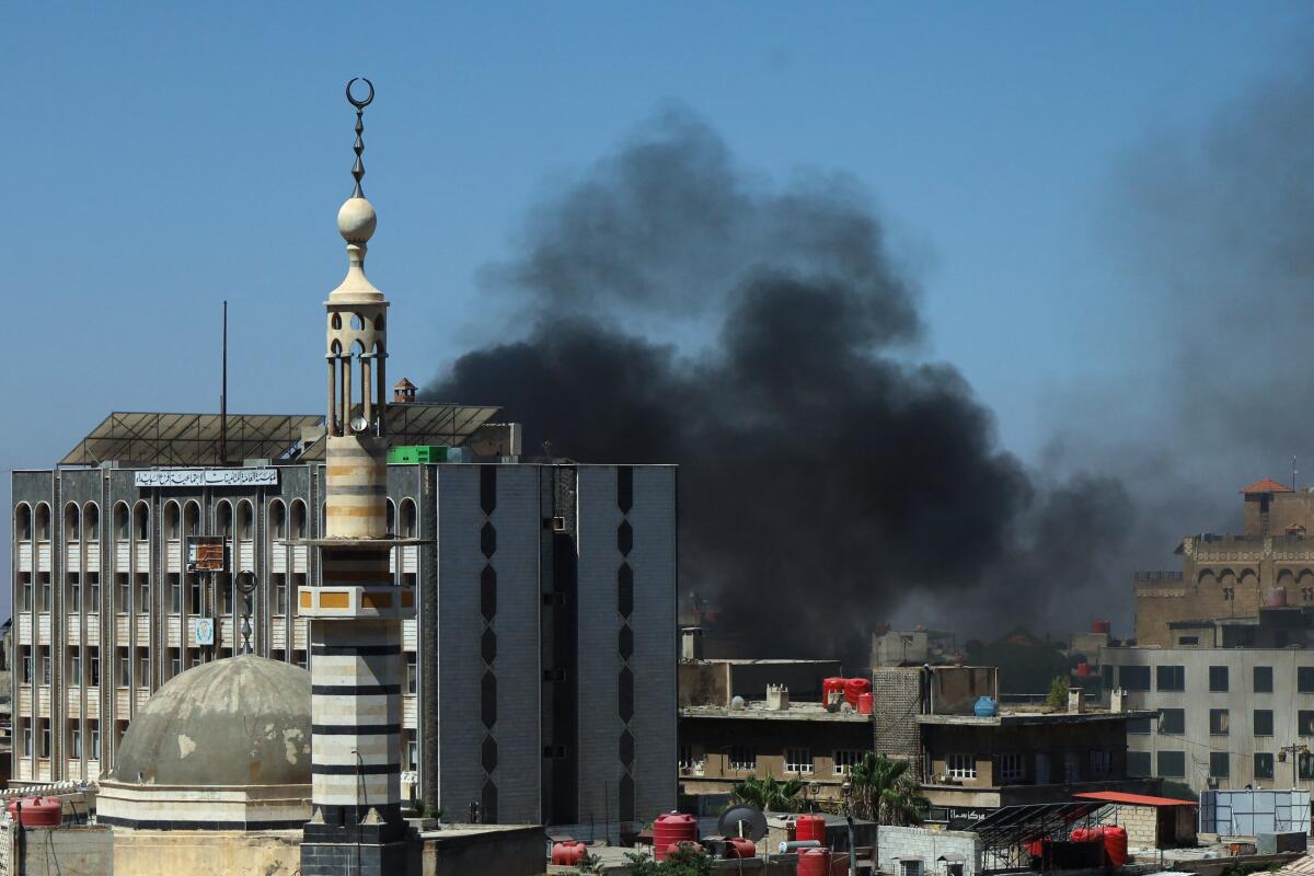 Smoke billows during clashes in the predominantly Druze city of Sweida