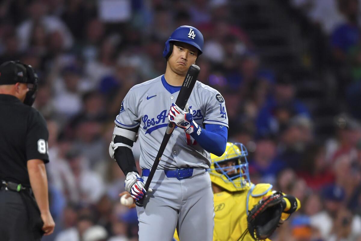Dodgers star Shohei Ohtani examines his bat before striking out in the fourth inning Saturday.