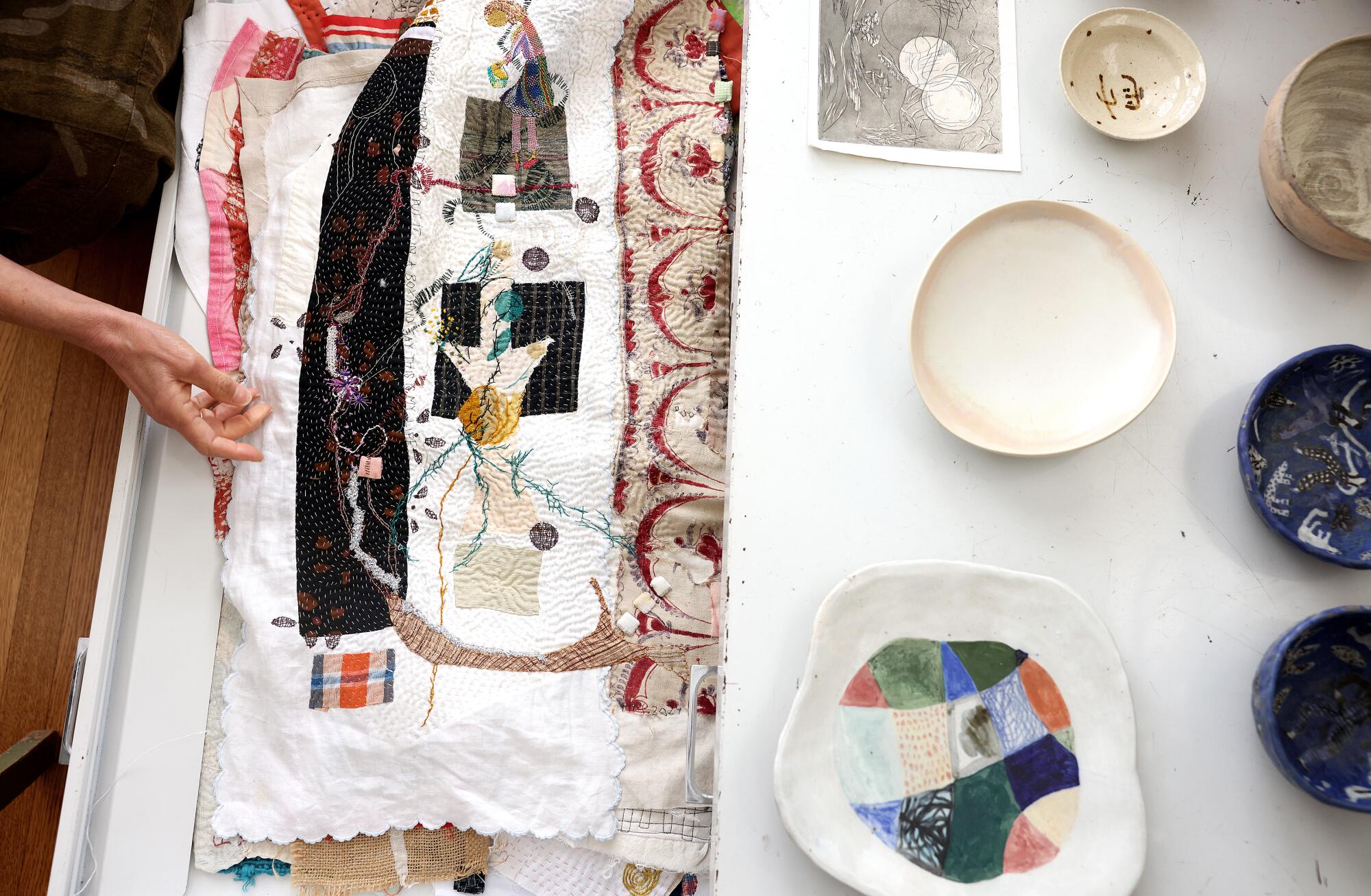 Debra Weiss looks through a cabinet full of her artwork at her apartment