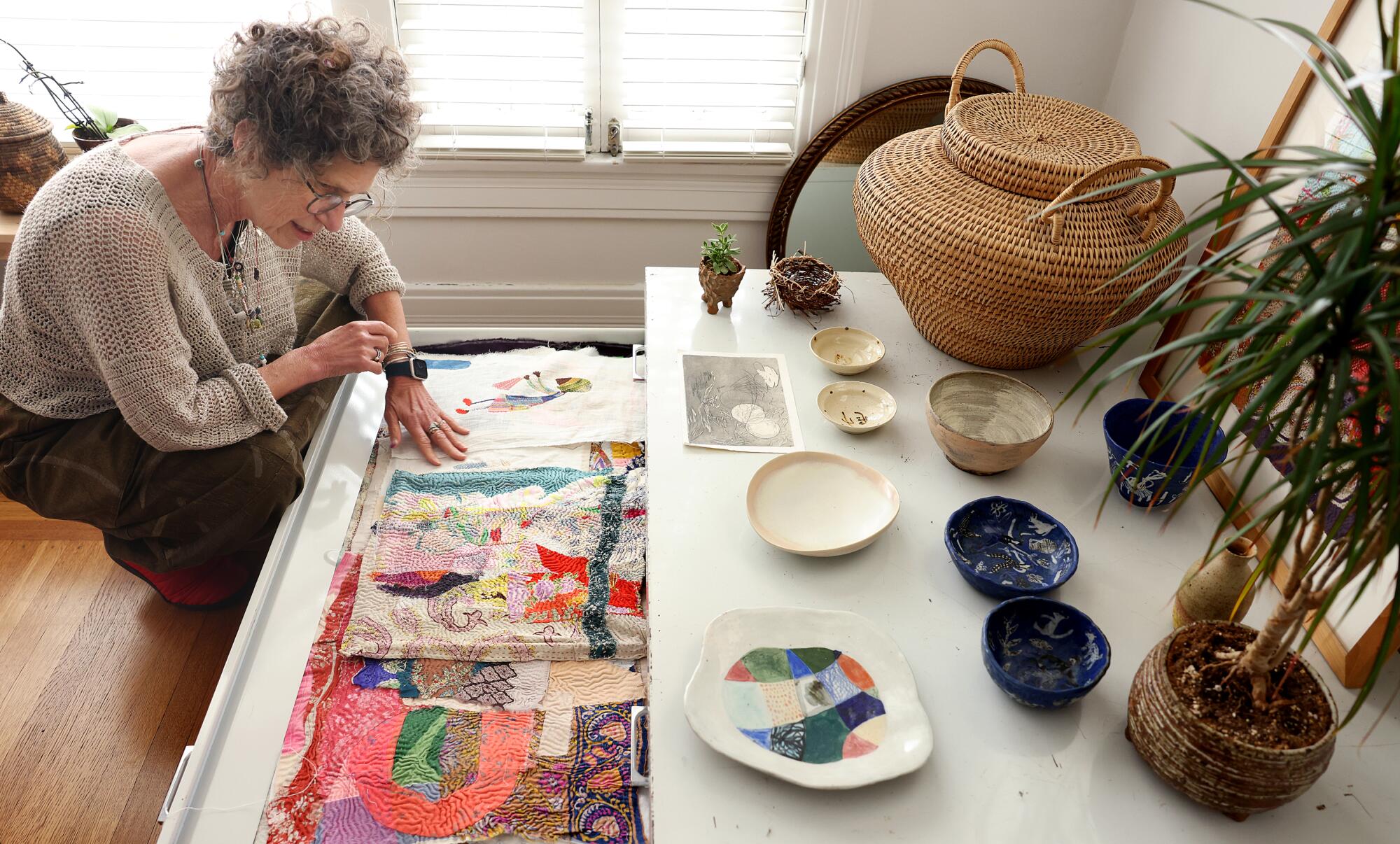 Artist Debra Weiss looks through a cabinet full of her work