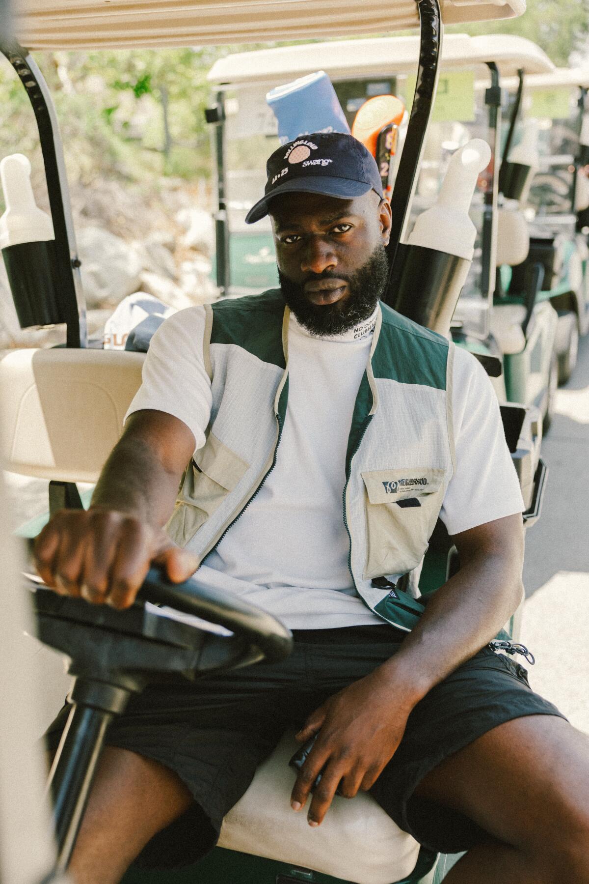 A man sitting at the wheel of a golf cart