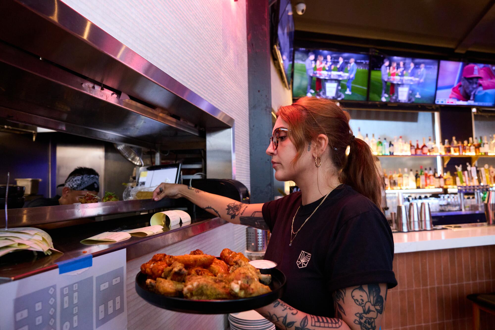 An employee cooking wings at Untamed Spirits
