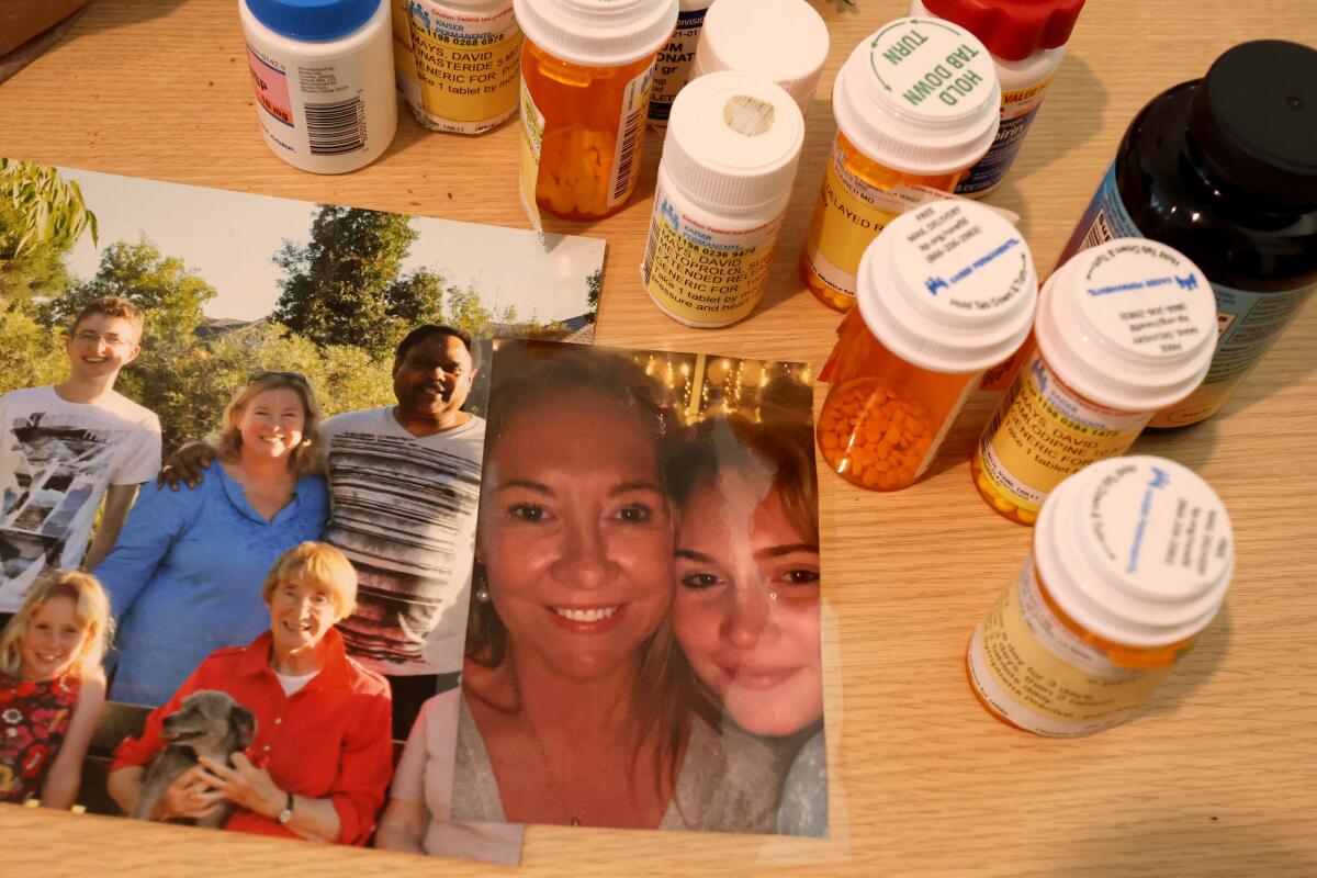 Bottles of medicine and a photo of a group of people and another of two women sit on a table
