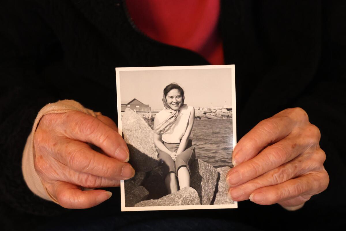 Reiko Kobata, 100, holds a photo of herself at 29 years old in her home in Gardena.