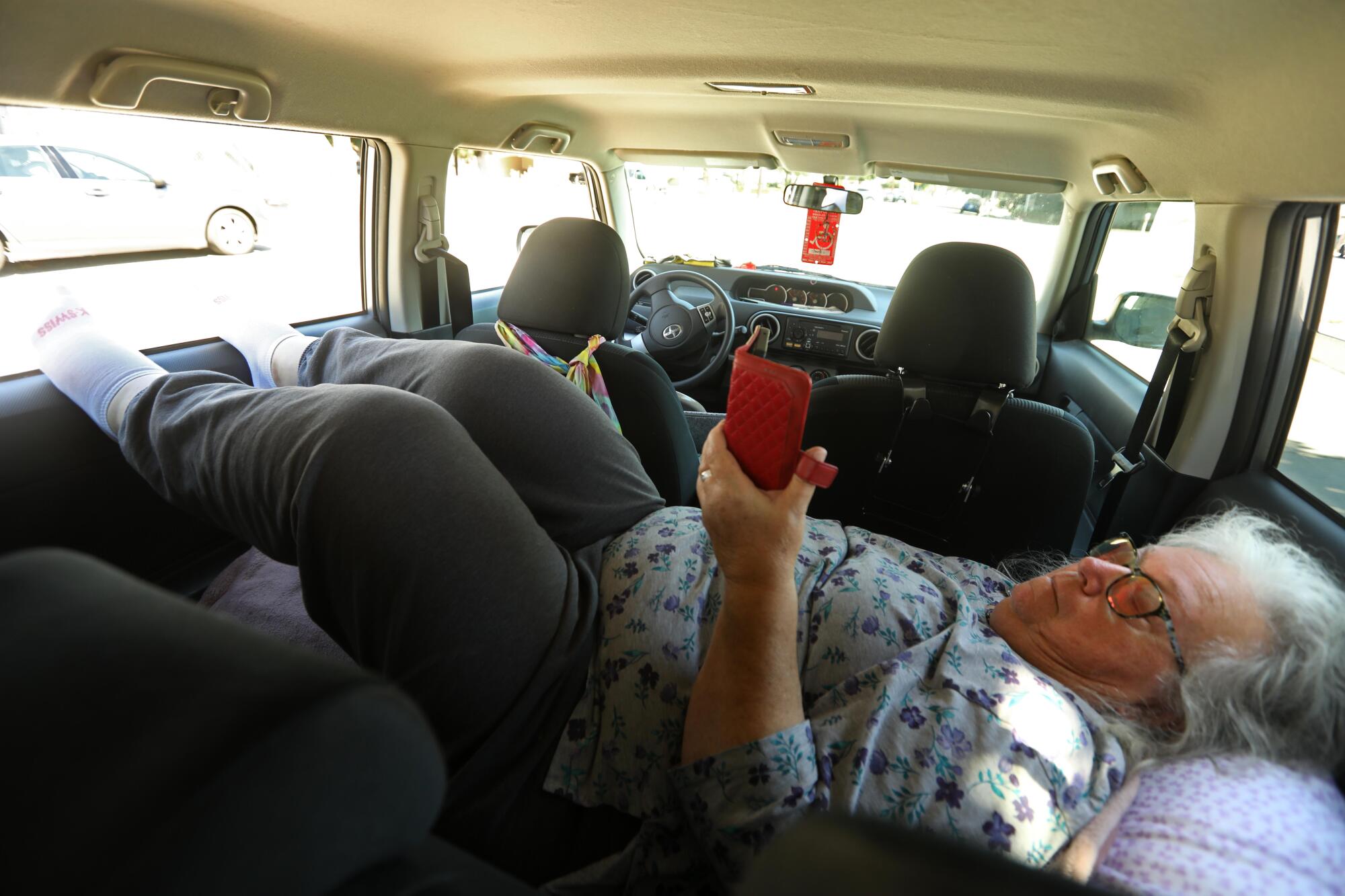 Jane Jefferies rests in her car and elevates her feet to reduce swelling in her legs in Santa Monica. 