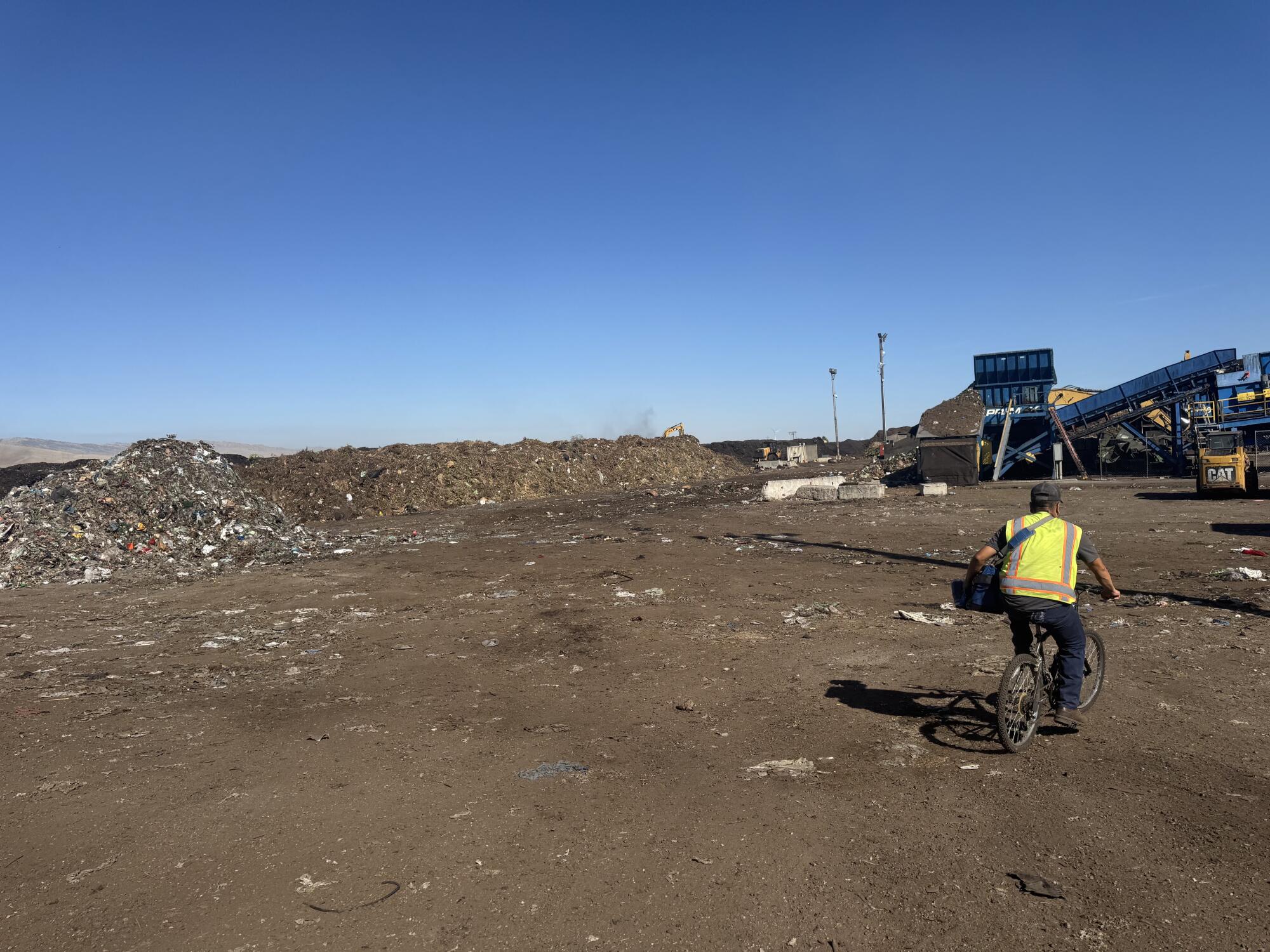 A worker at Recology's Blossom Valley composting site rides his bike back to the sorting machines after a break in Vernalis.