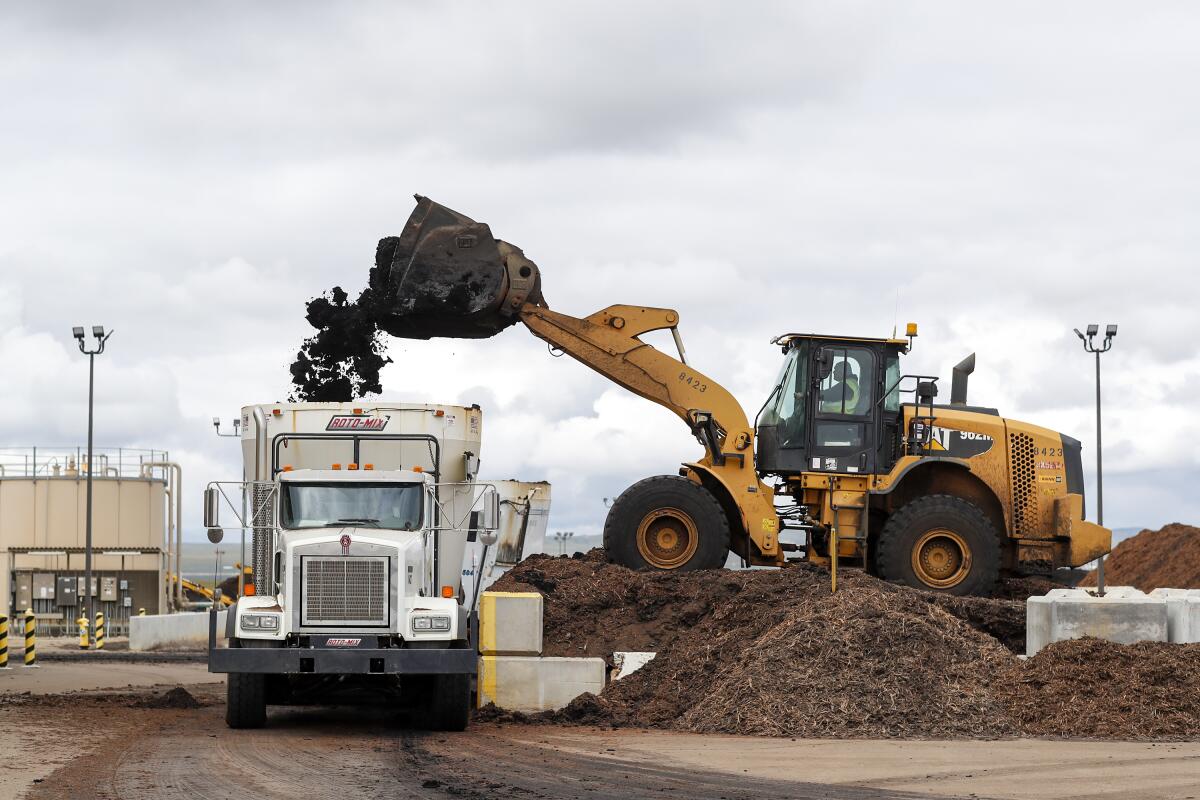 Material is loaded into a mixing truck where biosolids and amendments are combined then stored in climate controlled piles