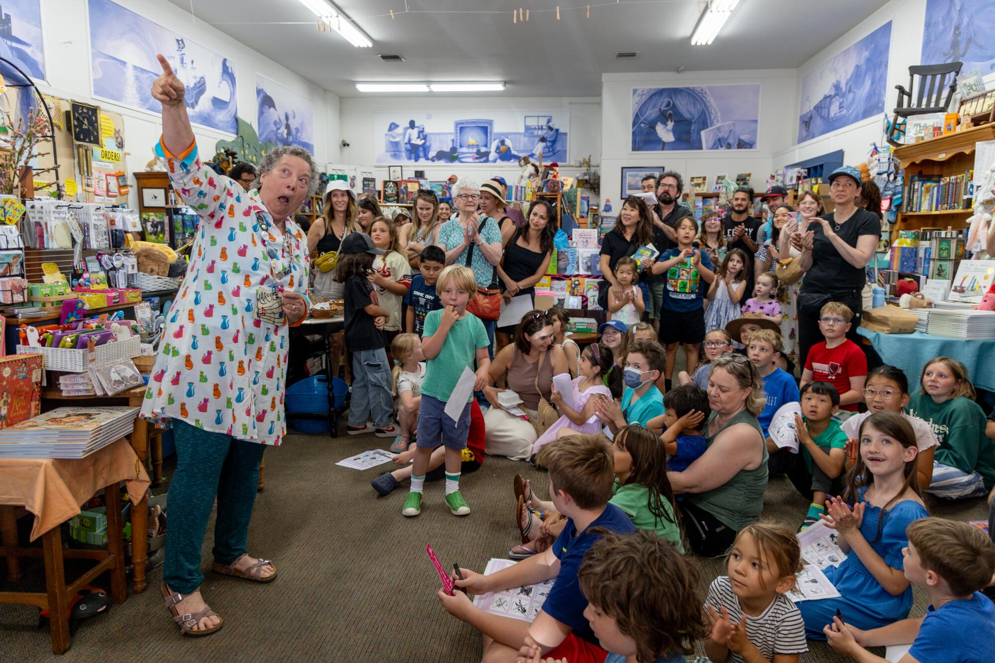 Maureen Palacios, owner of Once Upon a Time Bookstore, points at Pippi the cat making her descent