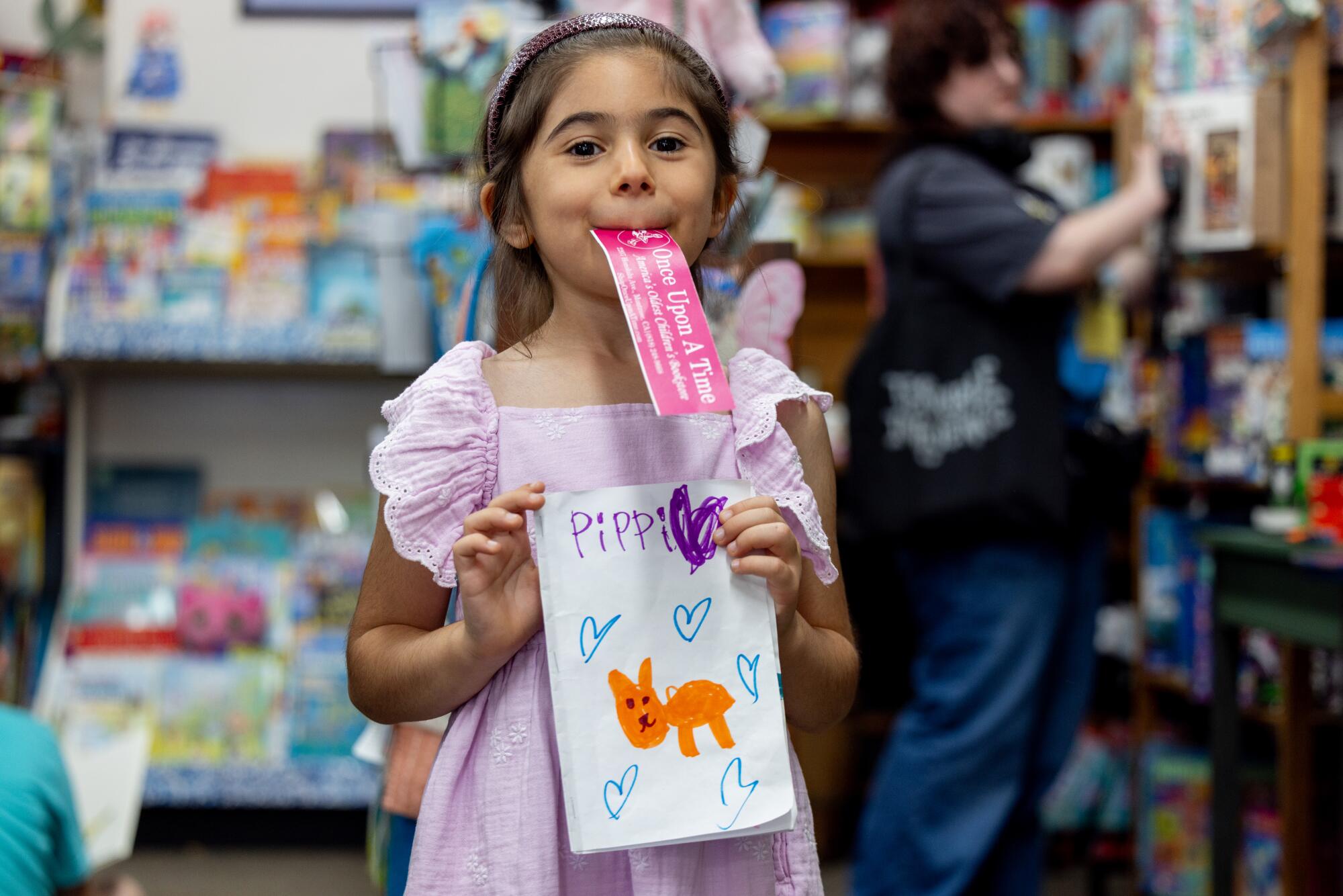 Megheti Feghali, 6, poses for a portrait with her writing contest entry for Pippi the cat's 10th birthday.