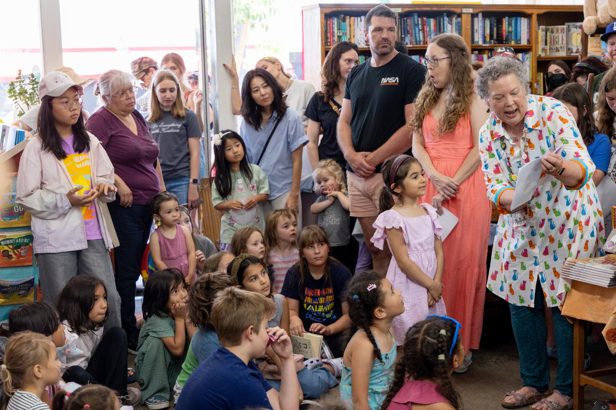 Bookstore owner Maureen Palacios reads Megheti Feghali's writing contest entry to kids and adults.