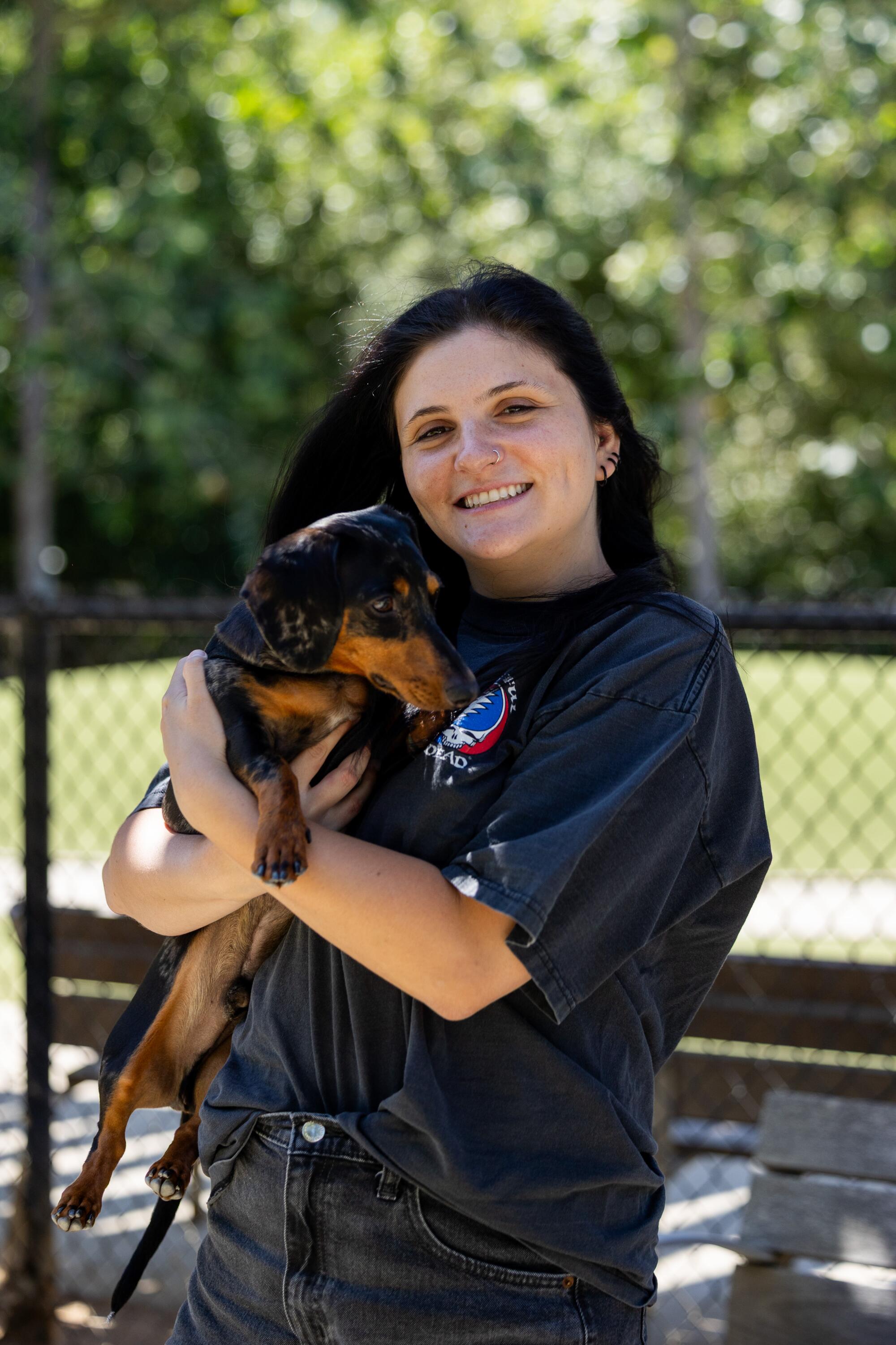 Ellena Whitfield holds her dog Zero at Bluff Creek Dog Park.