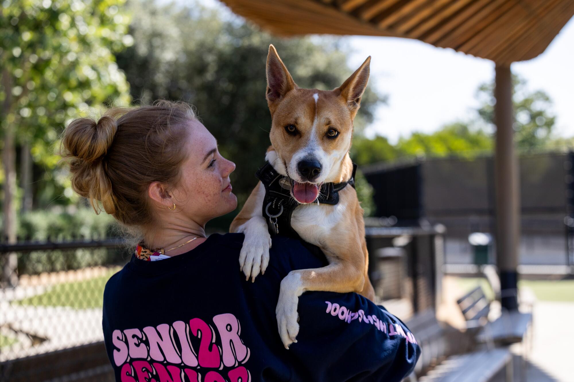 Cedar, who declined to give a last name, holds her dog Mika at Bluff Creek Dog Park.