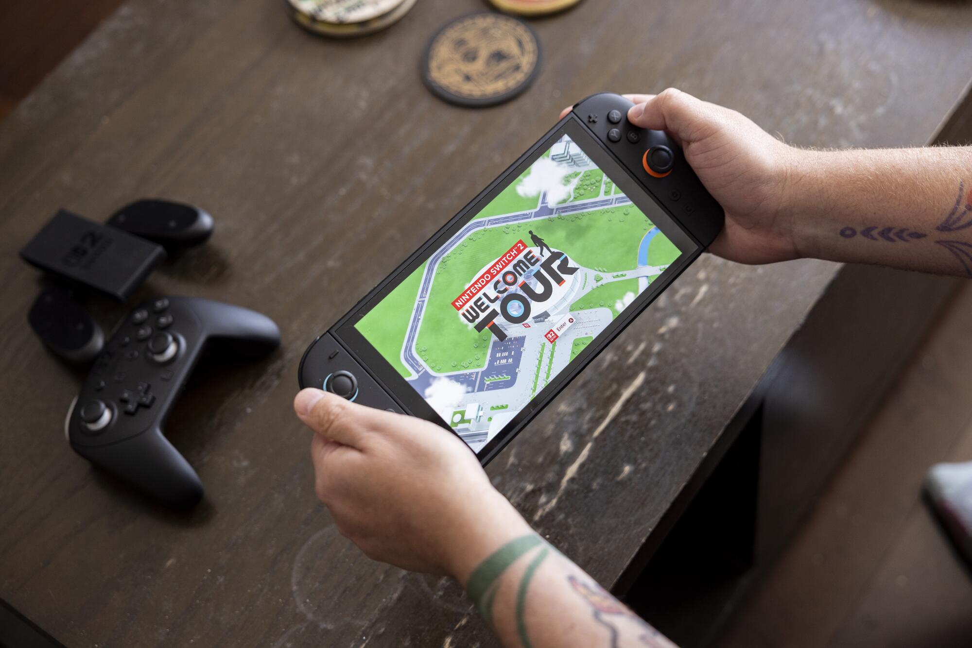 A reporter holds the Switch 2 in handheld mode. 