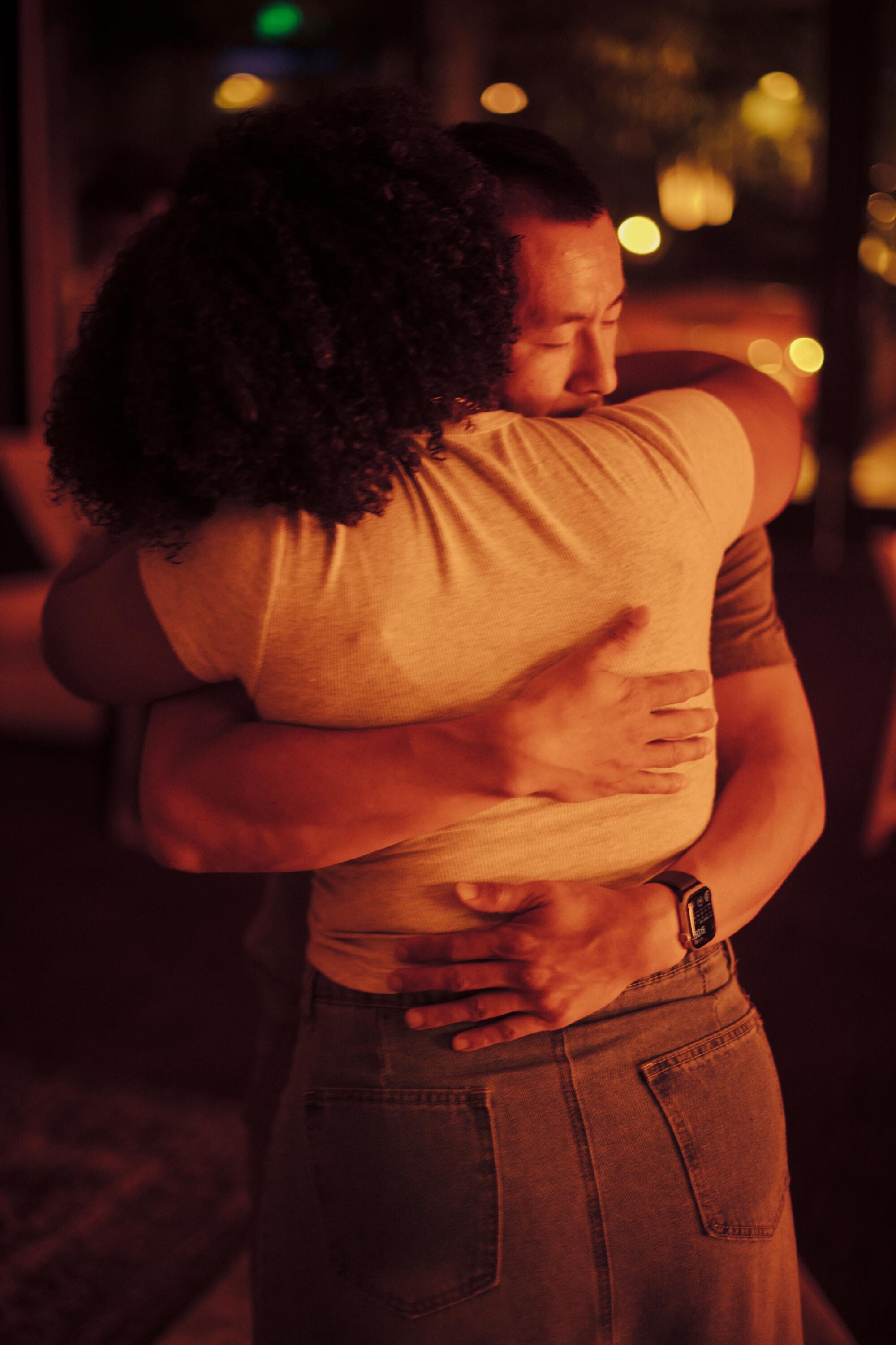 A man and woman embrace, eyes closed. 