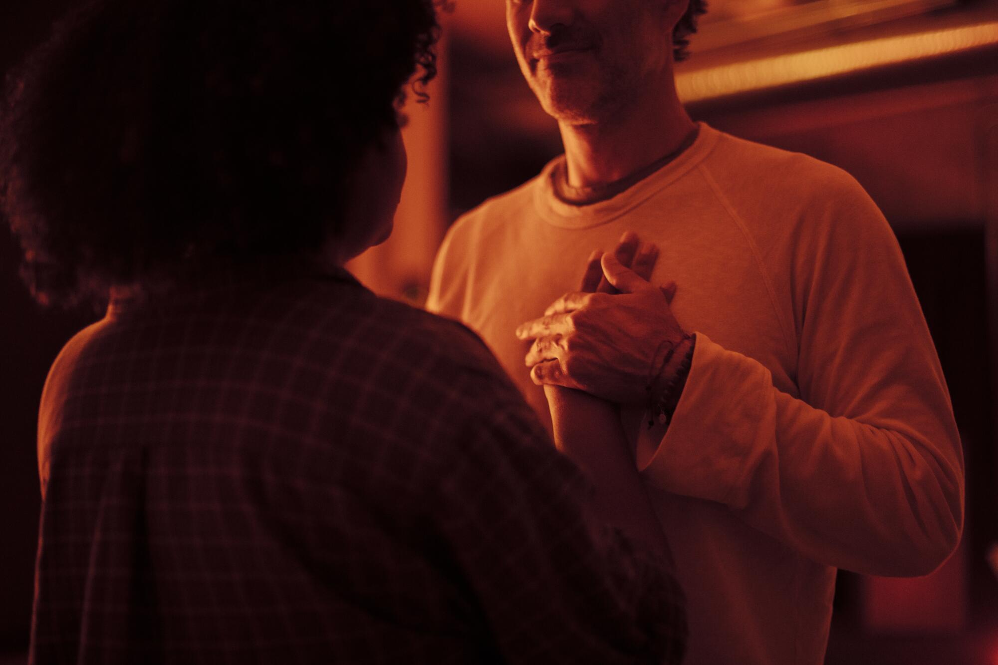A woman places her hand on her partner's heart.