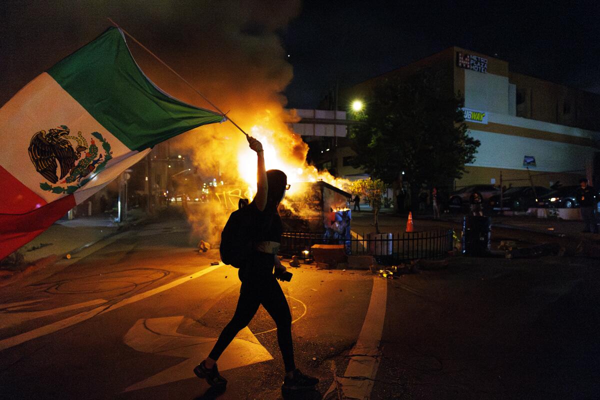 A demonstrator waves a Mexican flag