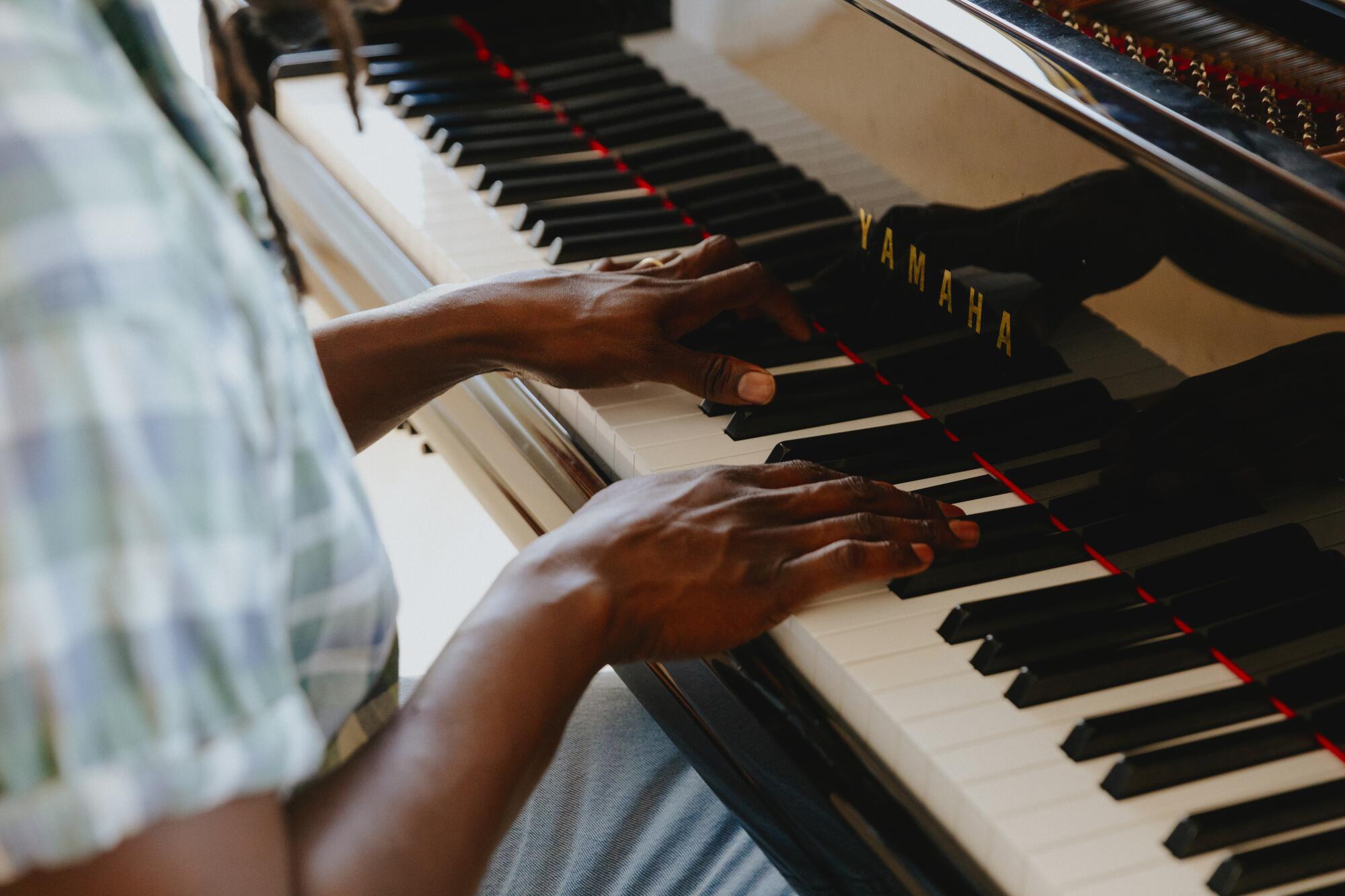 A man's hands on piano keys.