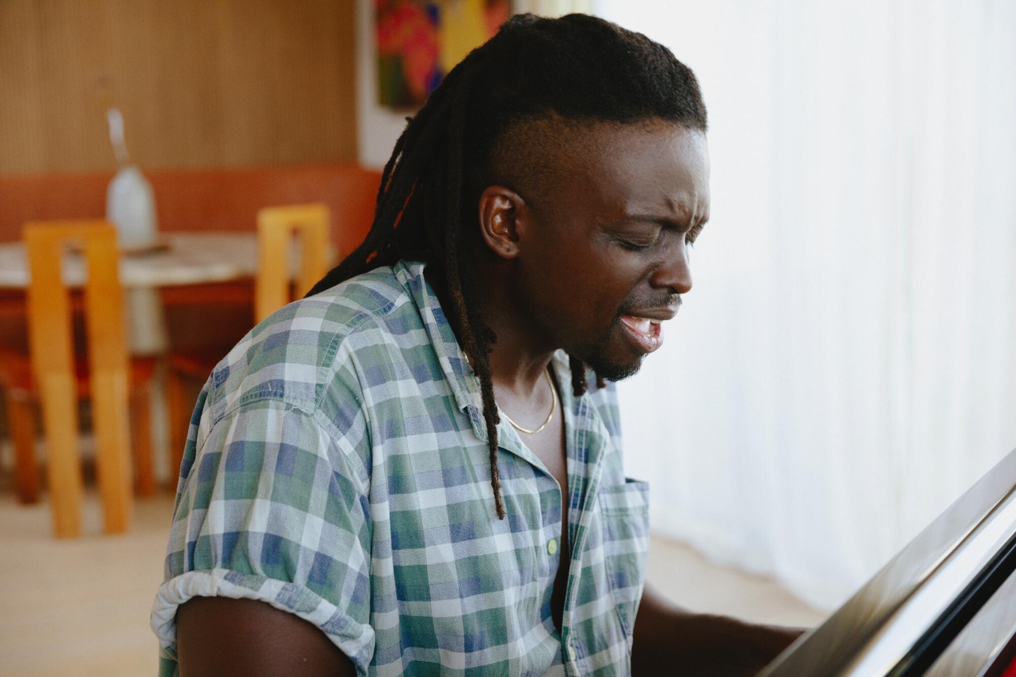 A man sings while playing piano.