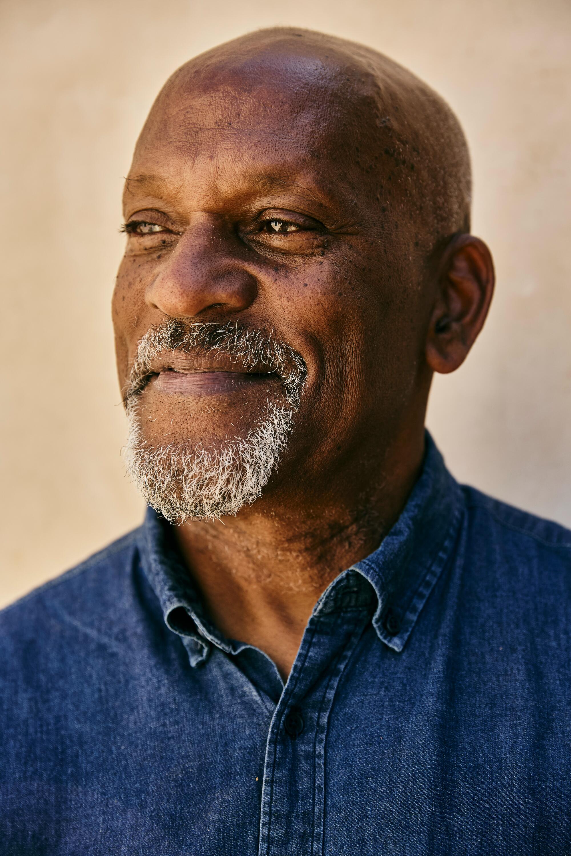 Close-up of a man in front of a wall.