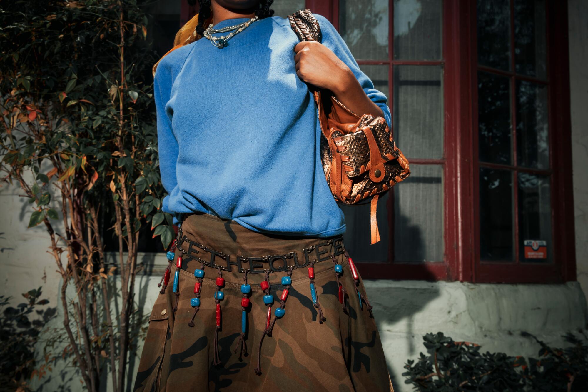 Kaamilah Thomas wears vintage Hanes top, Save the Queen belt, Chloé Silverado purse and Brook Callahan pendant.