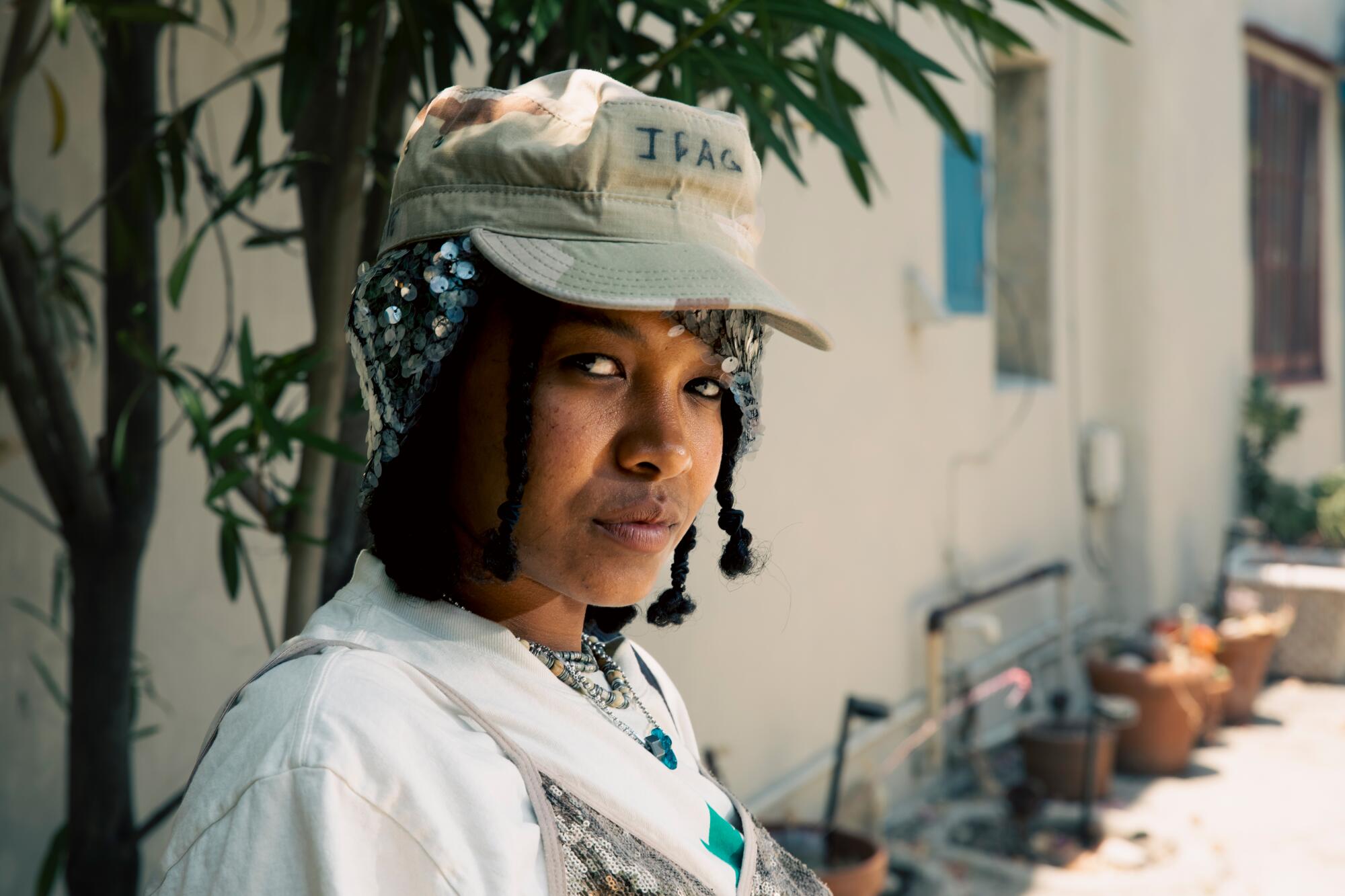 Kaamilah Thomas wears Anna Sui beanie with Dad’s army hat, Gen2 tee with Chan Luu sequin bra.