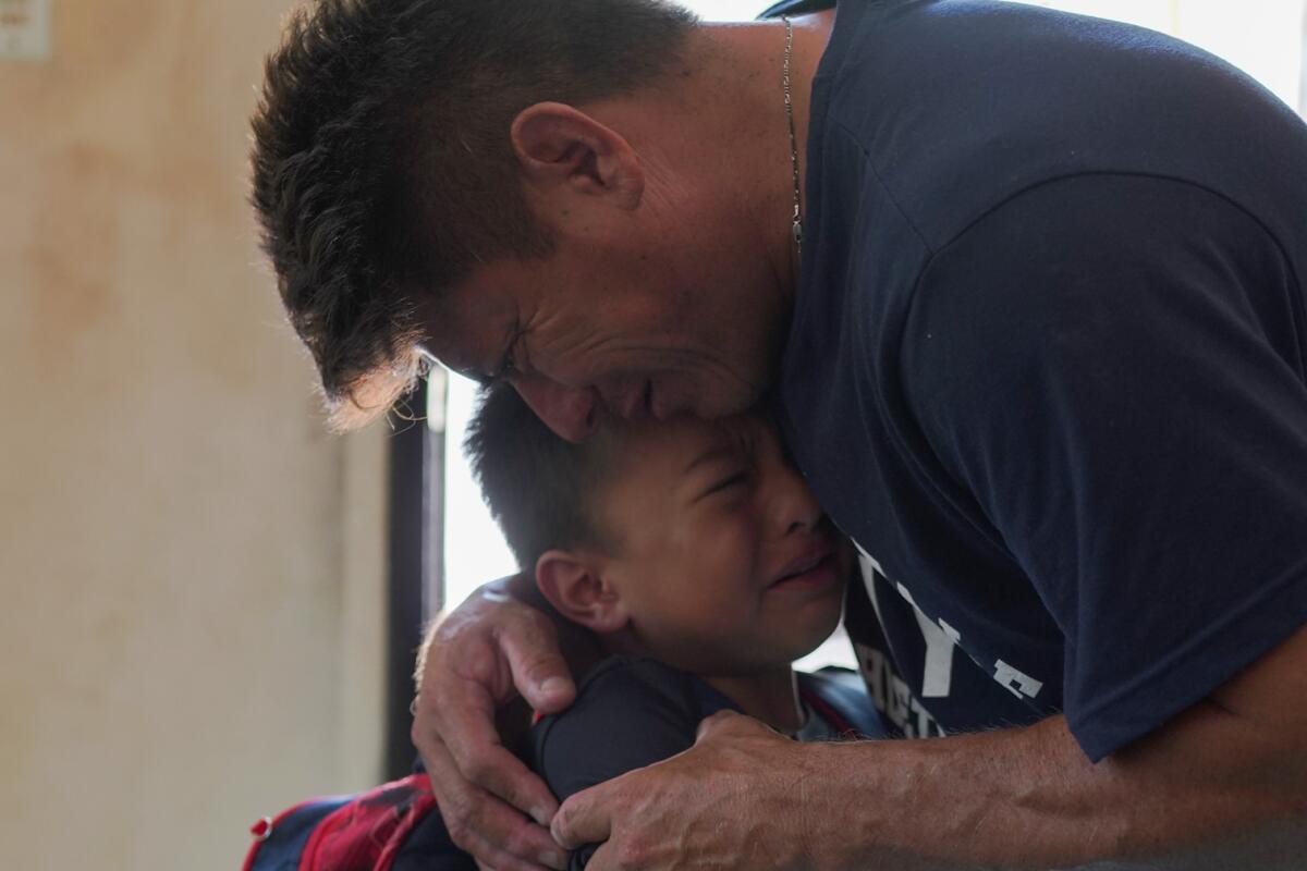 Jesus Cruz hugs his son Gabriel as they say goodbye