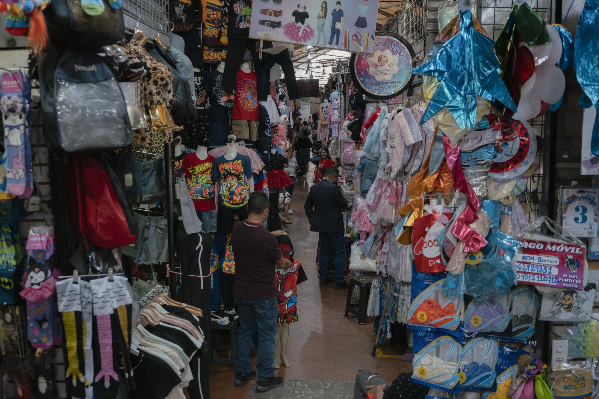 A man fixes a Spider-Man costume at the San Jacinto popular market in Caracas.