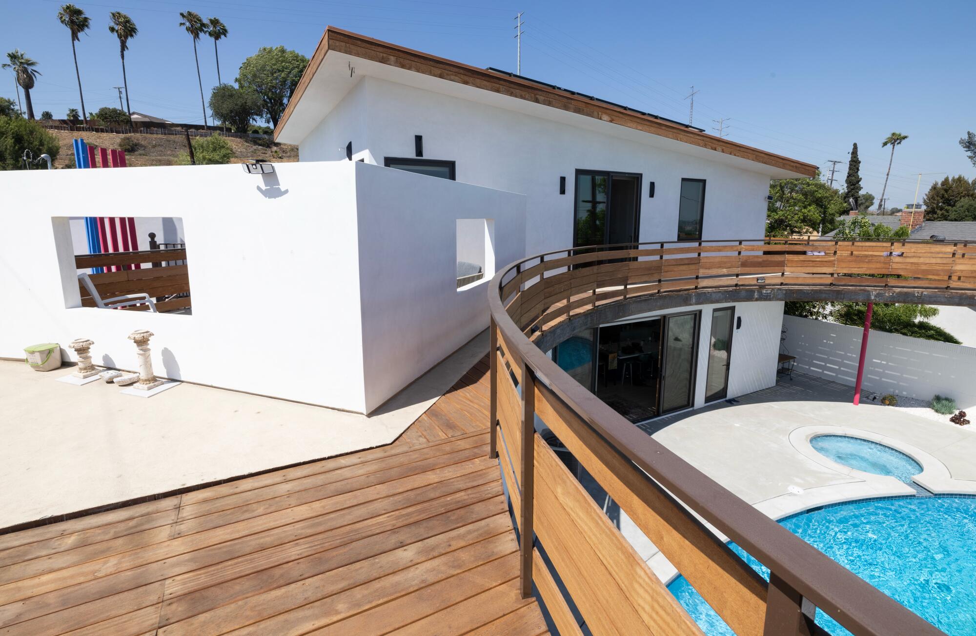 A second story balcony that curves around a swimming pool.