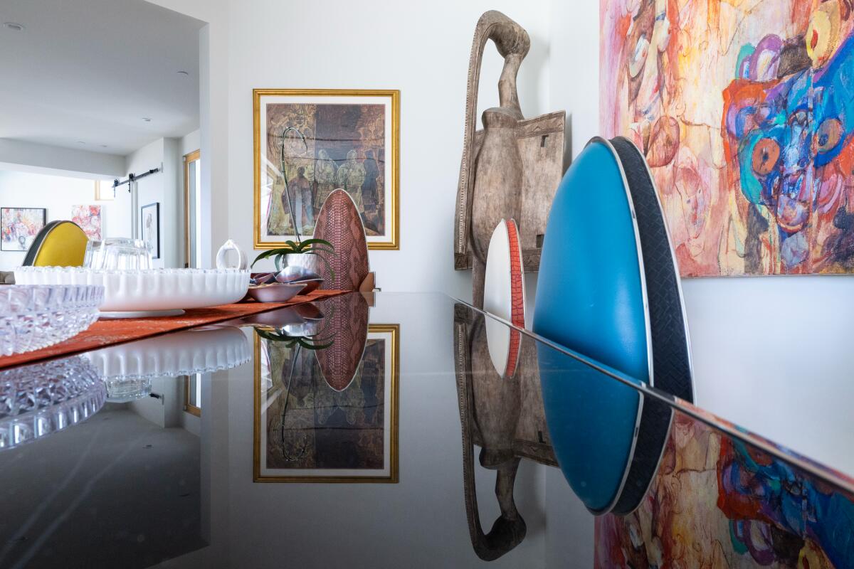 A dining room with colorful furniture and art.