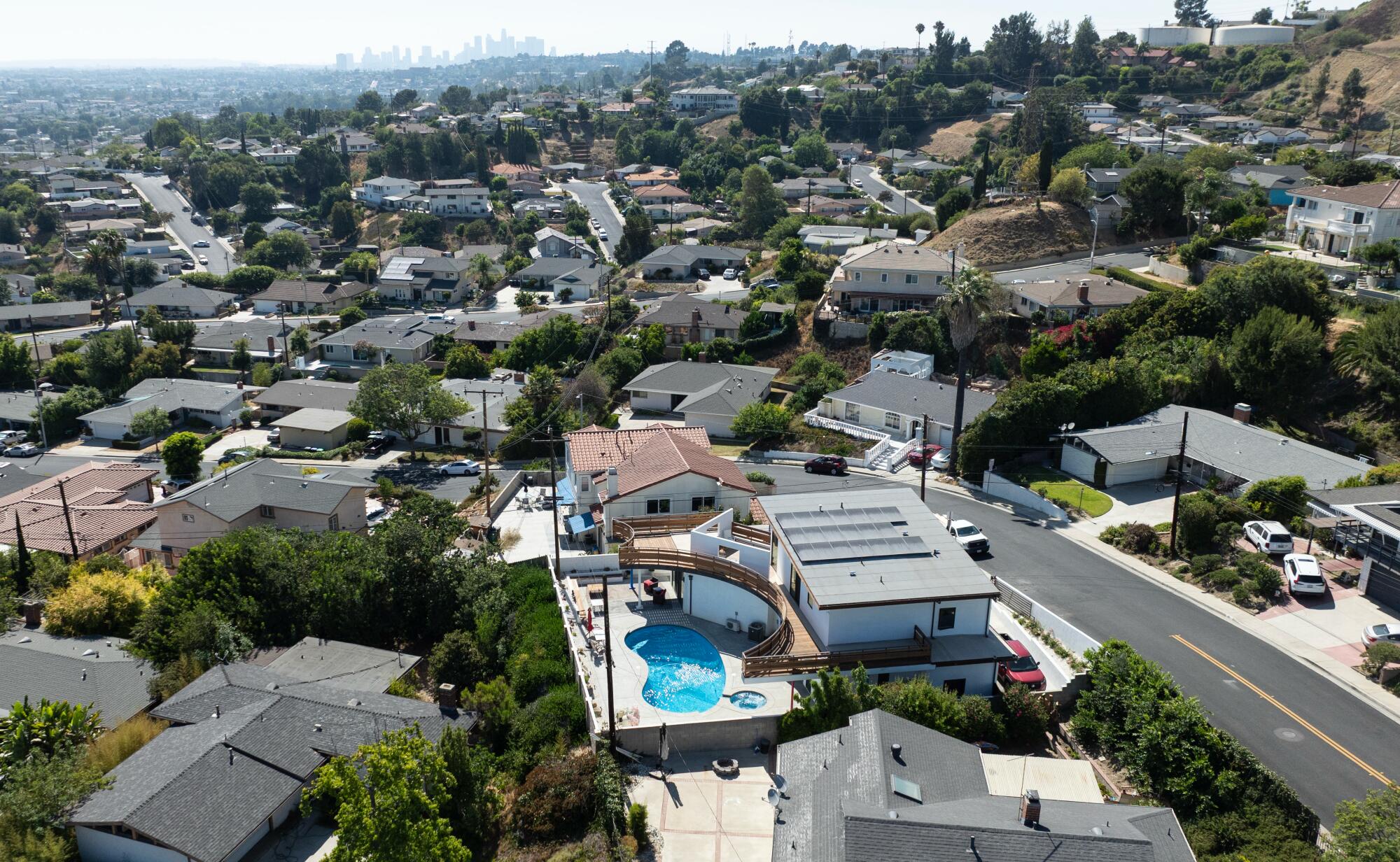 A drone shot of a pool home with downtown Los Angeles in the distance.