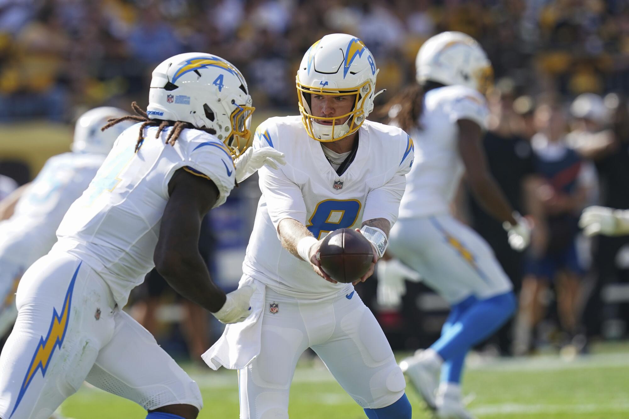 Chargers quarterback Taylor Heinicke hands off to running back Gus Edwards during a game against the Steelers.