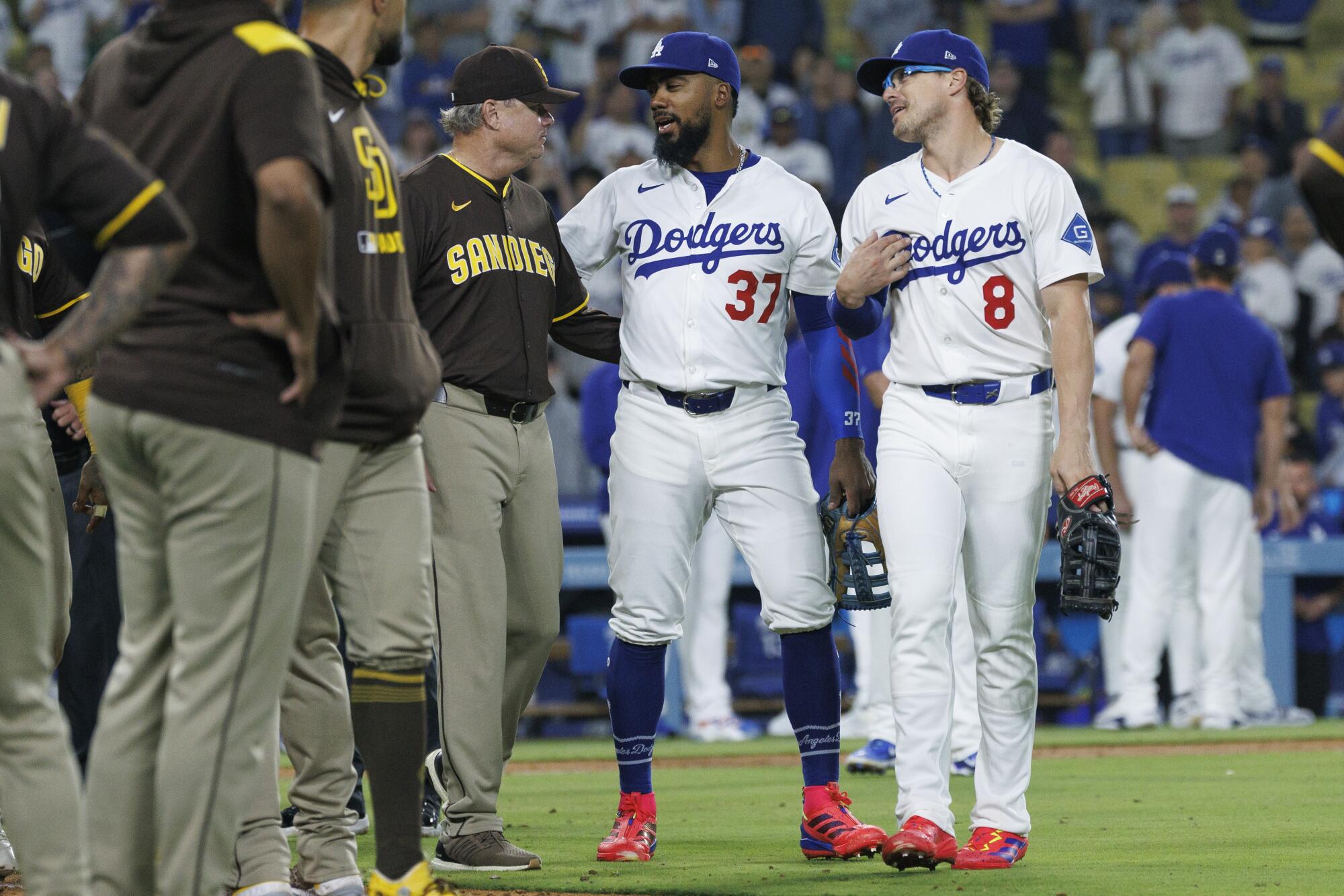 Dodgers Teoscar Hernandez (37) and Enrique Hernandez (8) calm things down as they walk with Padres manager Mike Shildt