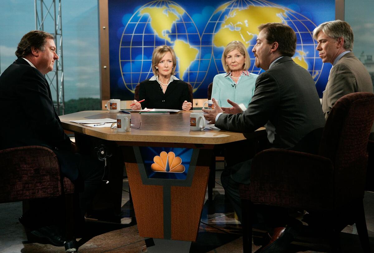 People gather around a table for a discussion
