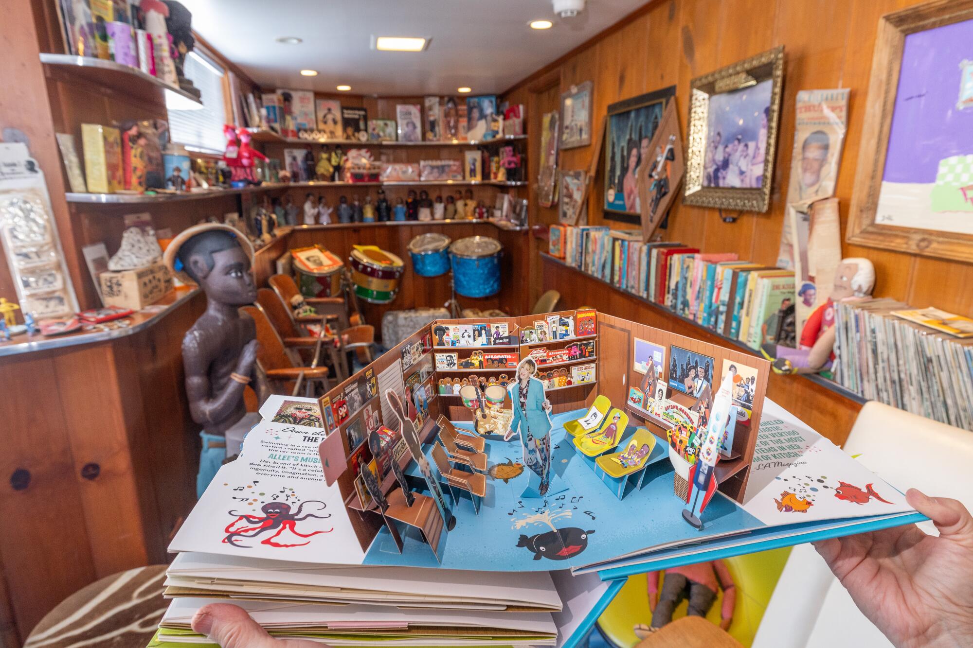A pop-up book page of a recreation room filled with collectibles inside the same rec room.