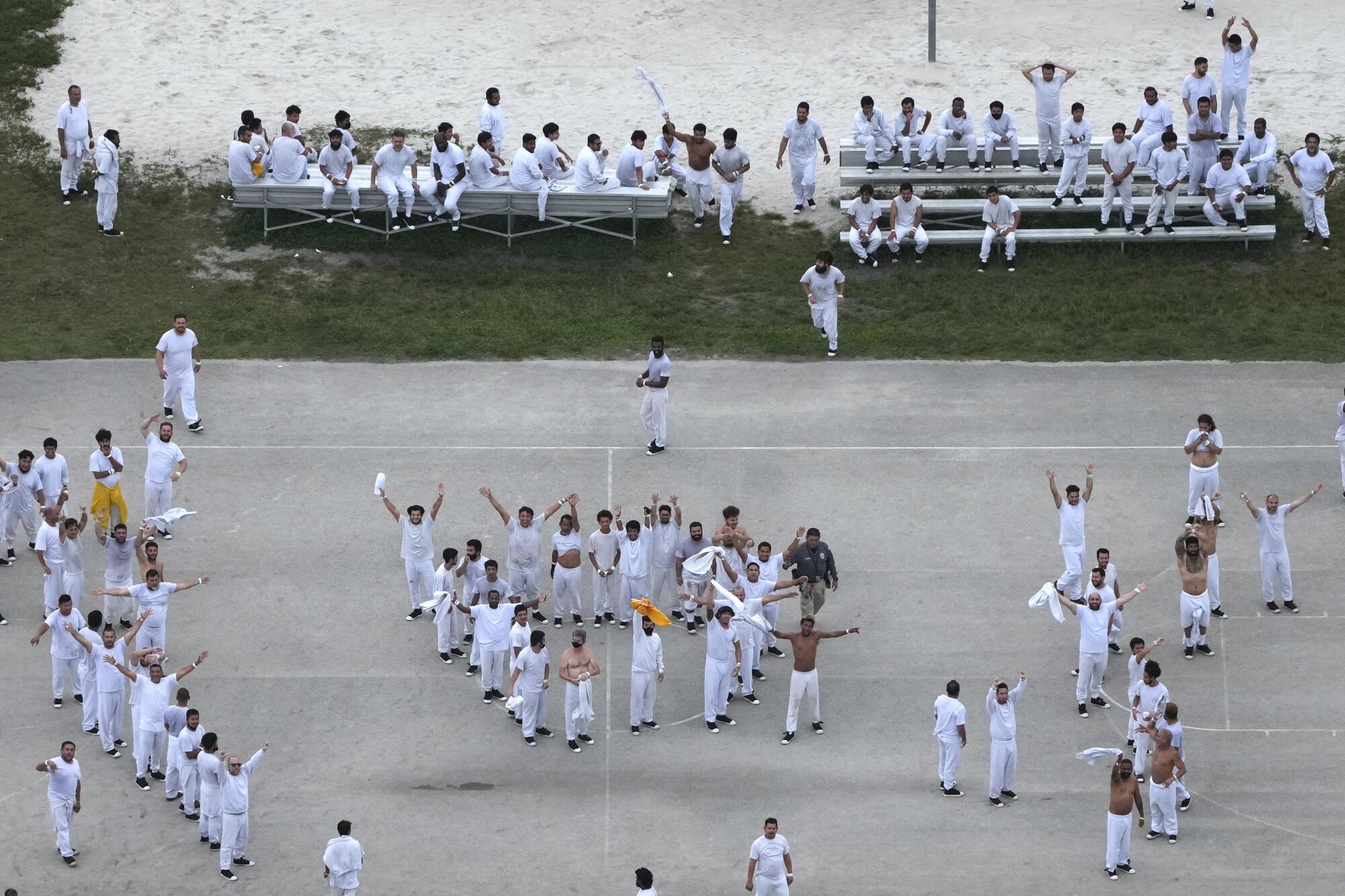 Groups of people in white clothes outdoors, some with hands outstretched