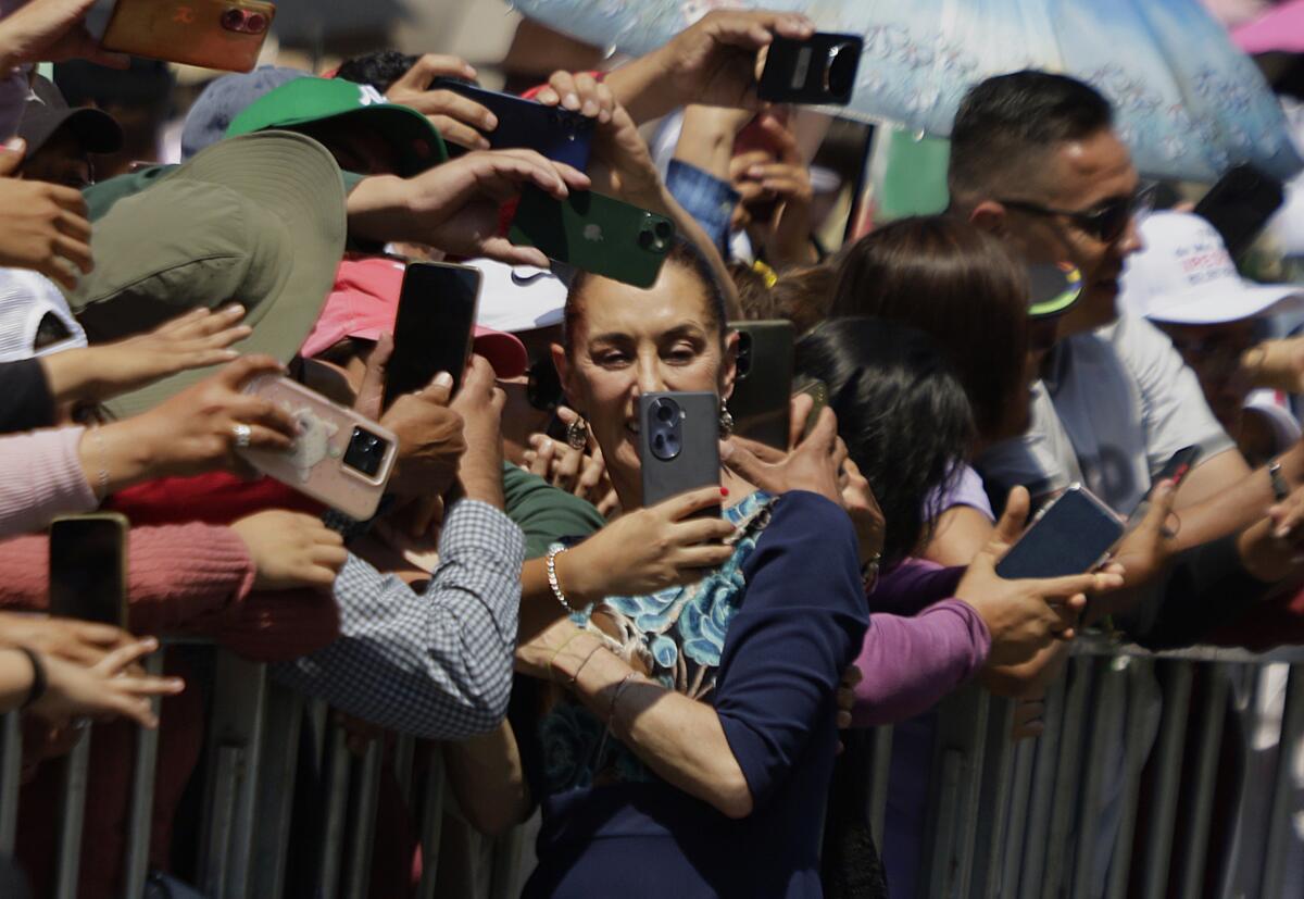 Claudia Sheinbaum, president of Mexico, greets her followers during a message she gives at the Zocalo in Mexico City