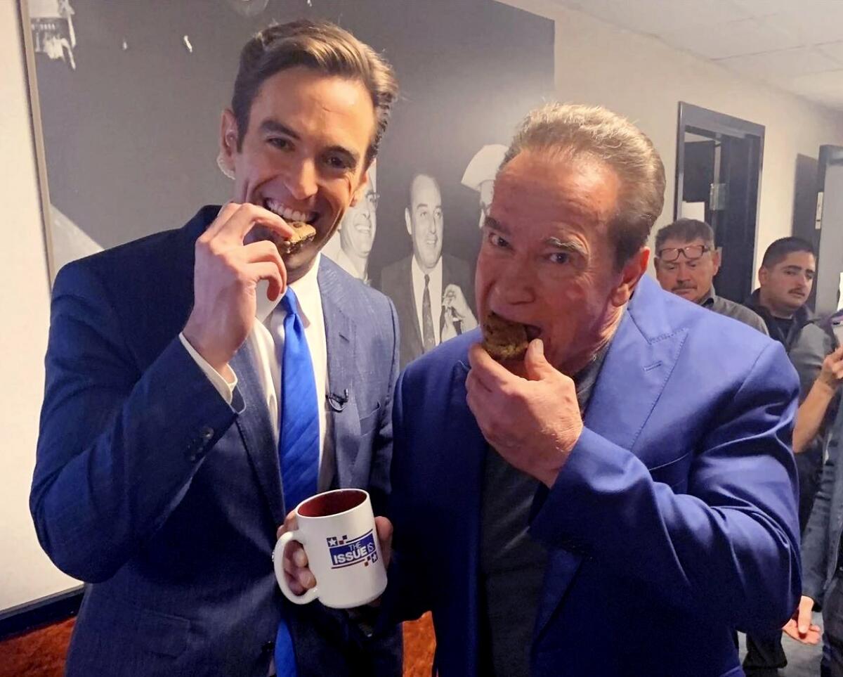 Michaelson and former Governor Arnold Schwarzenegger eating cookies
