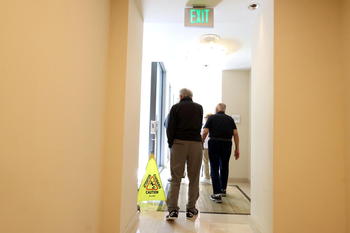 Joe Halper, 95, right, and Bill Klein, 94, walk down a hallway at Avocet Playa Vista on July 28, 2025 