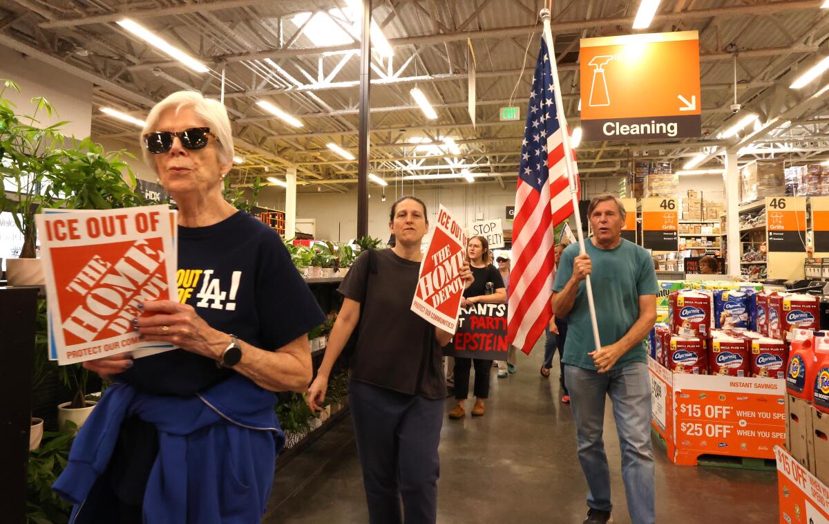 Anit-ICE activists march through the Home Depot in Pasadena on Aug. 6