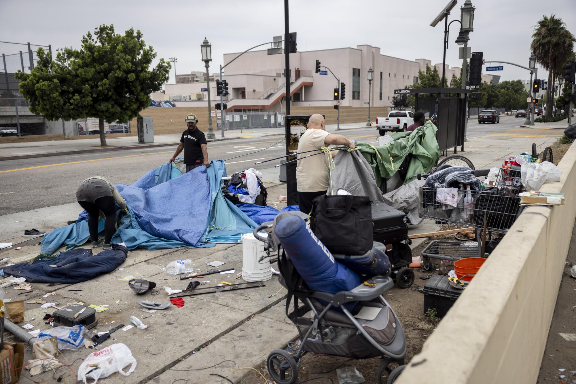 People experiencing homelessness pack their tents and belongings in downtown Los Angeles.