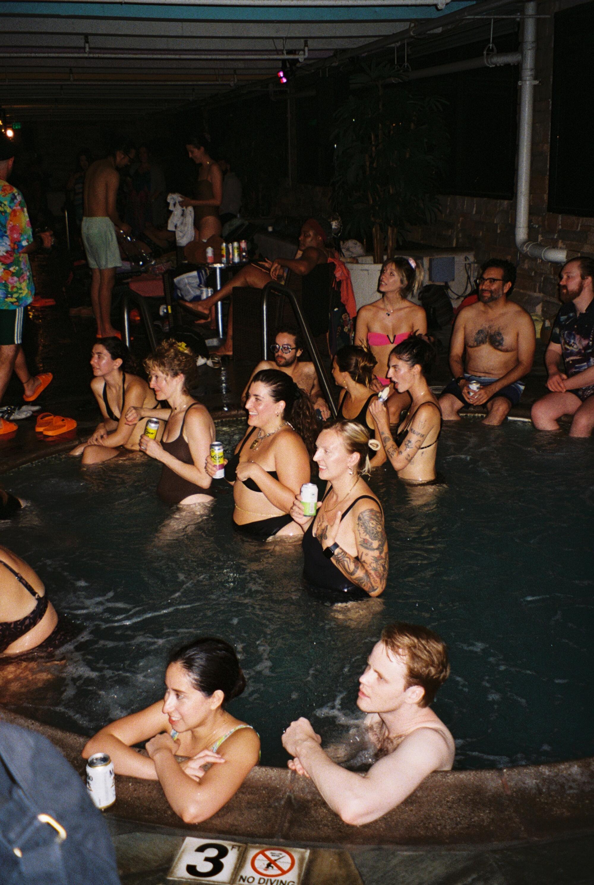 People lining Spa Palace hot tubs. 