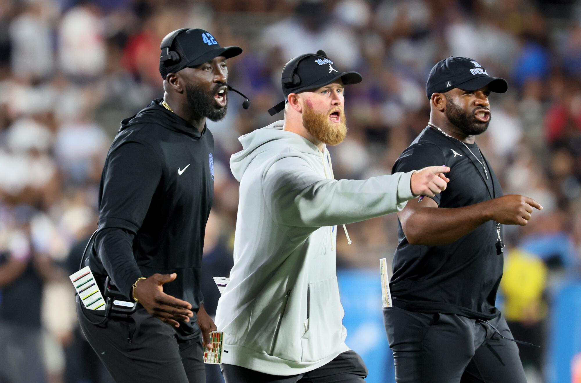 UCLA coach DeShaun Foster, and fellow coaches shout instructs during the Bruins' loss to Utah at the Rose Bowl.