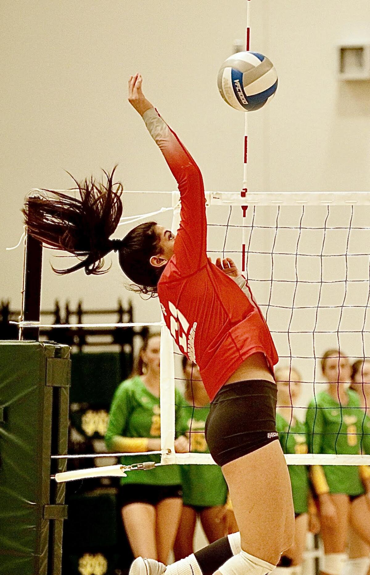 Layli Ostovar, of Mater Dei, extends to hit the volleyball during a match.