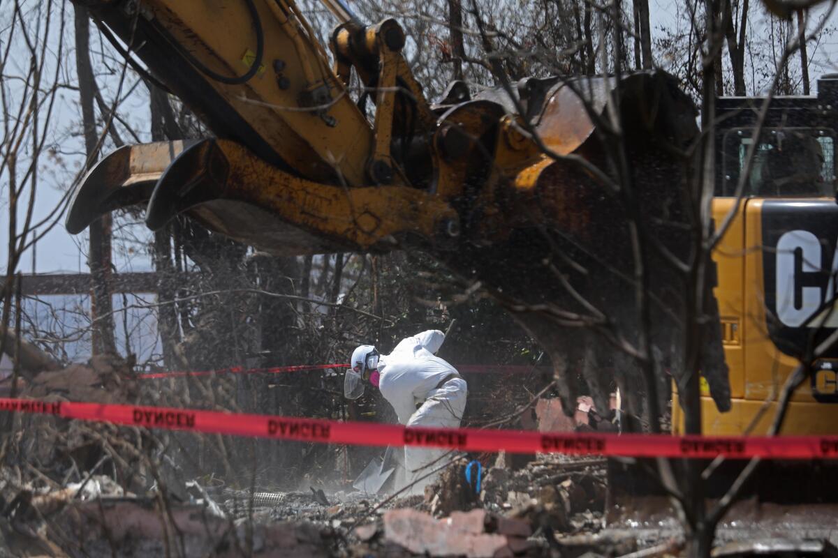 A worker clears debris from a home destroyed in the Palisades fire in Pacific Palisades in April
