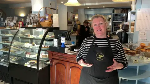 Kate Rumsey, owner of Rumsey's Chocolaterie in Thame, Oxfordshire, stood in the middle of her shop smiling and talking