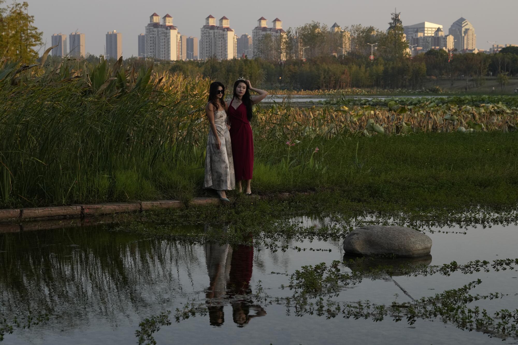Women near ponds and water plants at the "Fish Tail" sponge park in Nanchang, China.