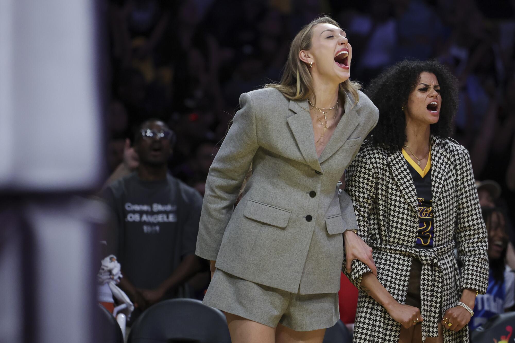 Sparks forward Cameron Brink and guard Rae Burrell, who are injured, shout and celebrate from the bench.