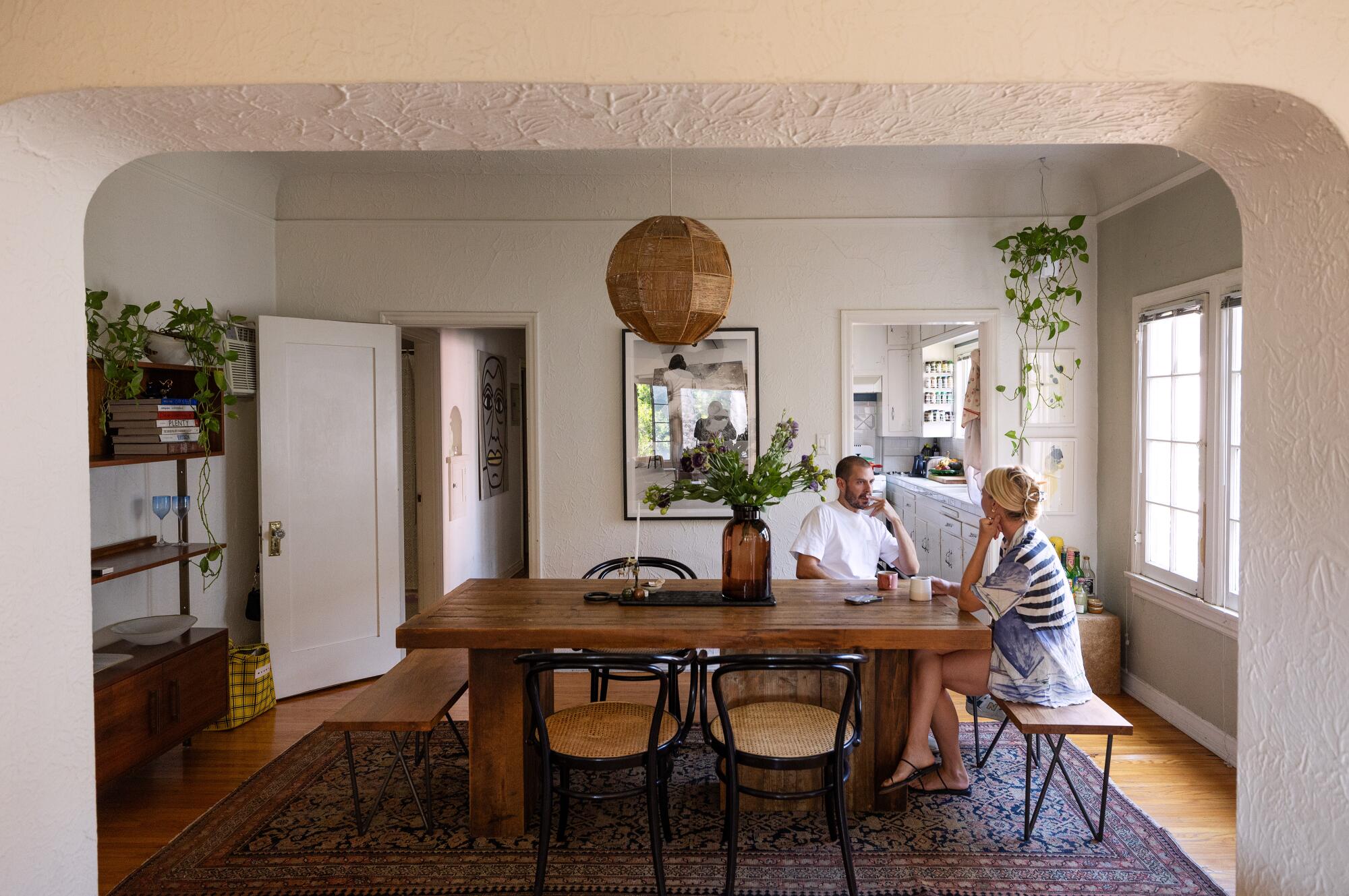Samuel Gibson and wife Natalie Babcock sit at their dining room table.