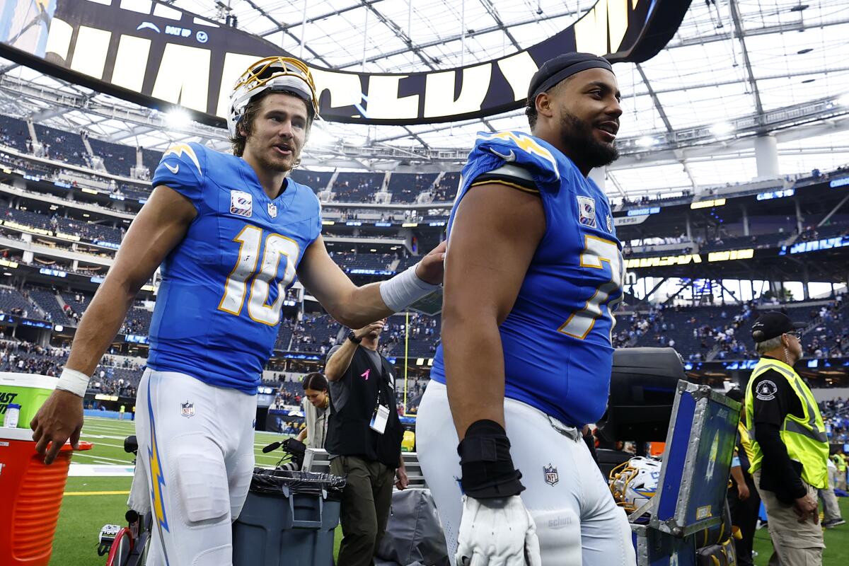 Chargers quarterback Justin Herbert, left, and offensive tackle Rashawn Slater walk off the field.